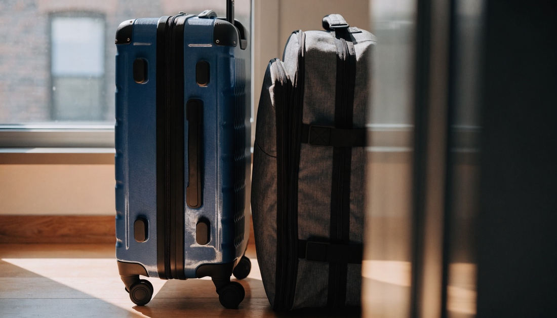 Deep-blue hardside suitcase beside a softside suitcase
